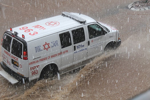 אמבולנס מדא בנסיעה בגשם בפתח תקווה, צילום: ברוך הופמן דוברות מדא